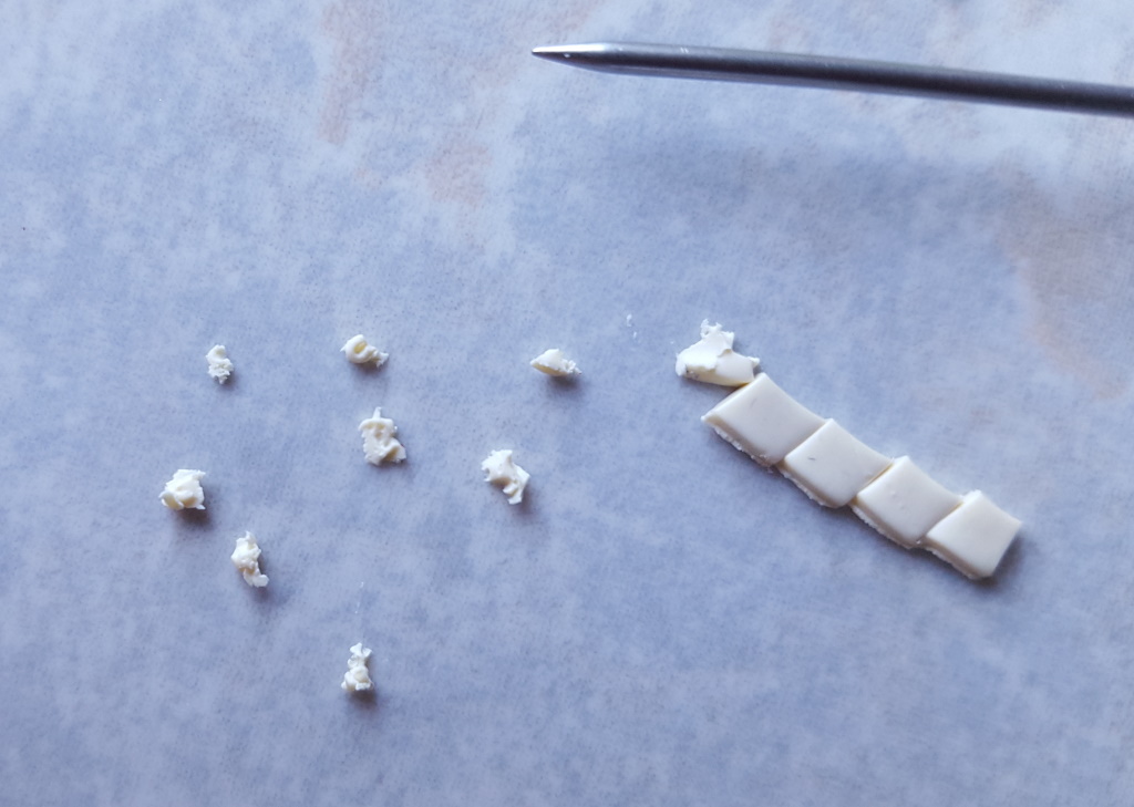 Étape de création d'un charm en fimo en forme de kébab miniature ou sandwich grec : découper le fromage.