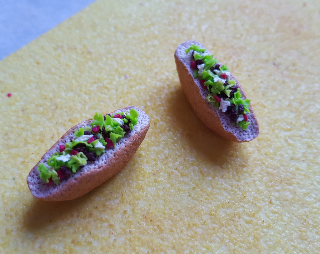 Étape de création d'un charm en fimo en forme de kébab miniature ou sandwich grec : garnir le pain.