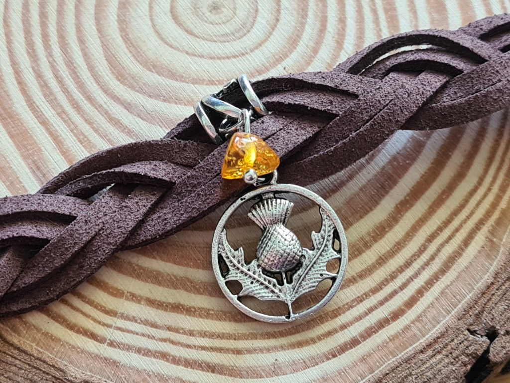 Gros plan sur une breloque chardon d’Écosse.